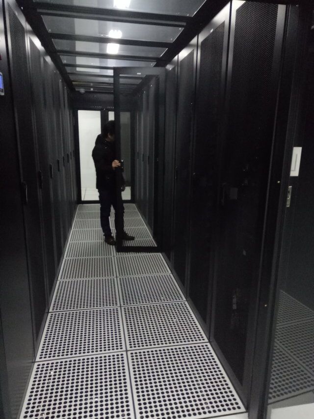 数据中心机房内服务器机柜通道与巡检人员实拍照片